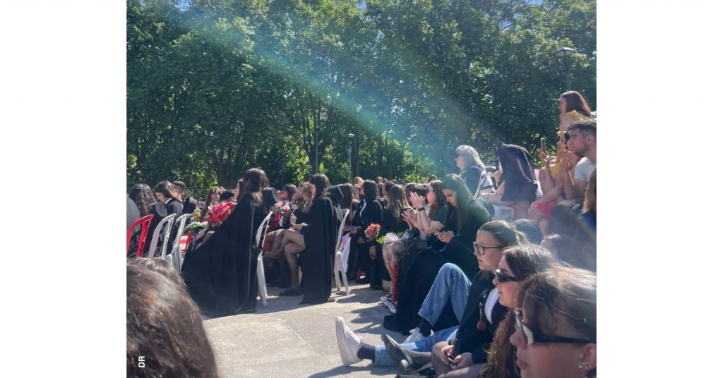 Grupo de estudantes trajados é mostrado de perfil, sentado em cadeiras, enquanto assiste à cerimónia da bênção de finalistas da ESECS.