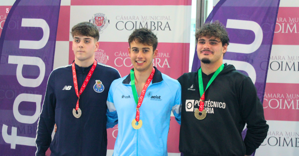 Três rapazes aparecem abraçados, com medalhas ao peito. São nadadores de diferentes instituições de ensino superior.