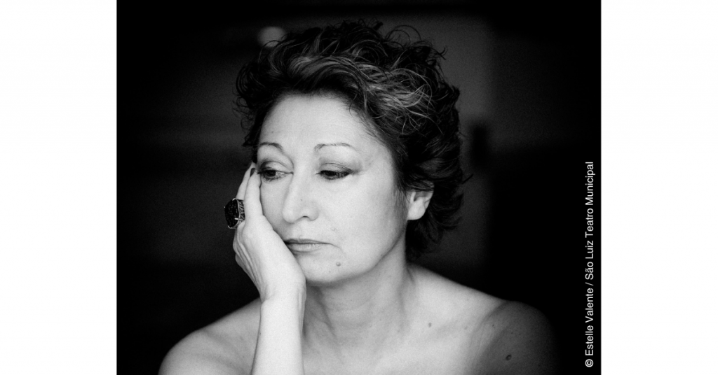 A bailarina e coreógrafa Olga Roriz aparece representada numa fotografia a preto e branco, dos ombros para cima. A sua mão direita apoia a cara e os seus olhos estão baixos, a apontar para a sua direita e para baixo.