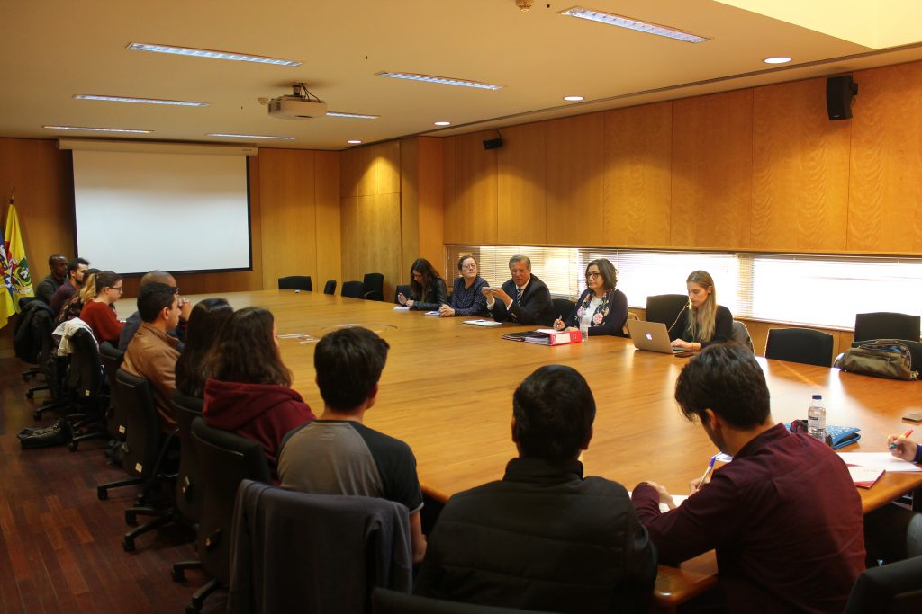 Sala de reuniões da ESECS, com estudantes e docentes presentes, sentados a uma grande mesa.
