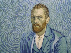 Imagem com autorretrato do pintor Vincent Van Gogh, visto do peito para cima, vestido com casaco e colete azuis e camisa branca. A barba e cabelo ruivos. O fundo em riscos de azul.