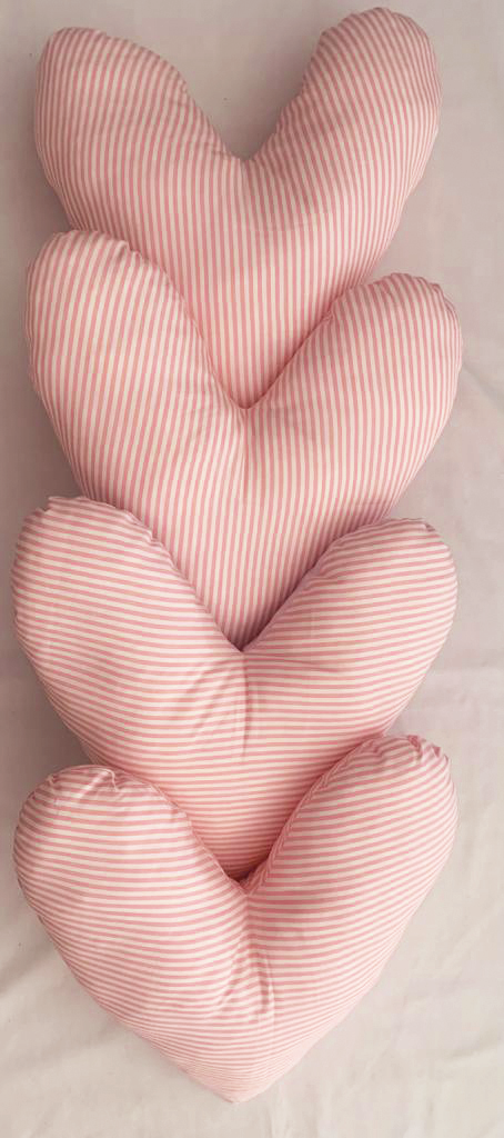 Vista superior de um quatro almofadas em forma de coração, dispostas verticalmente.